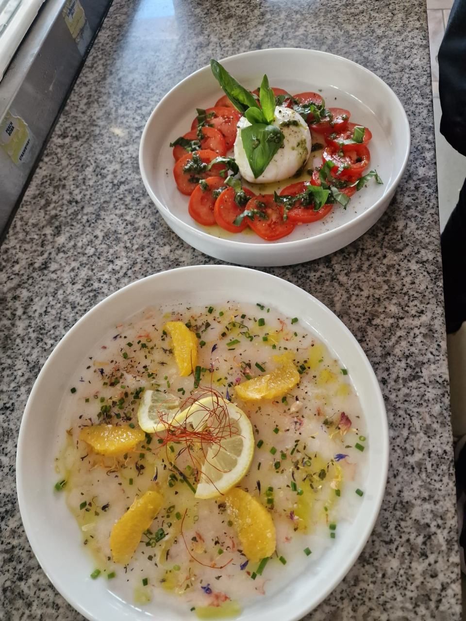 Deux assiettes de nourriture sont posées sur un comptoir en granit