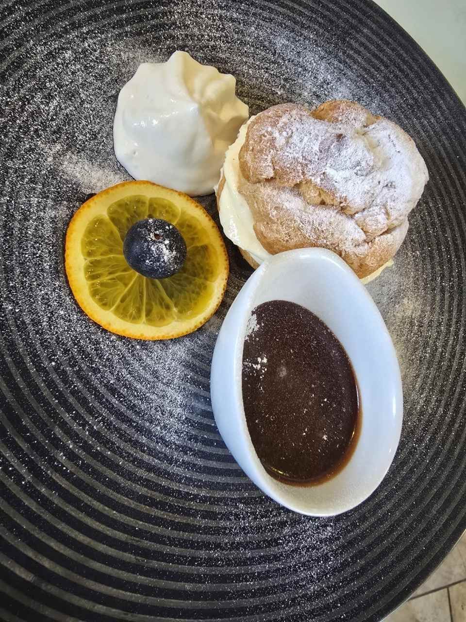 Une assiette de nourriture avec un bol de sauce au chocolat dessus