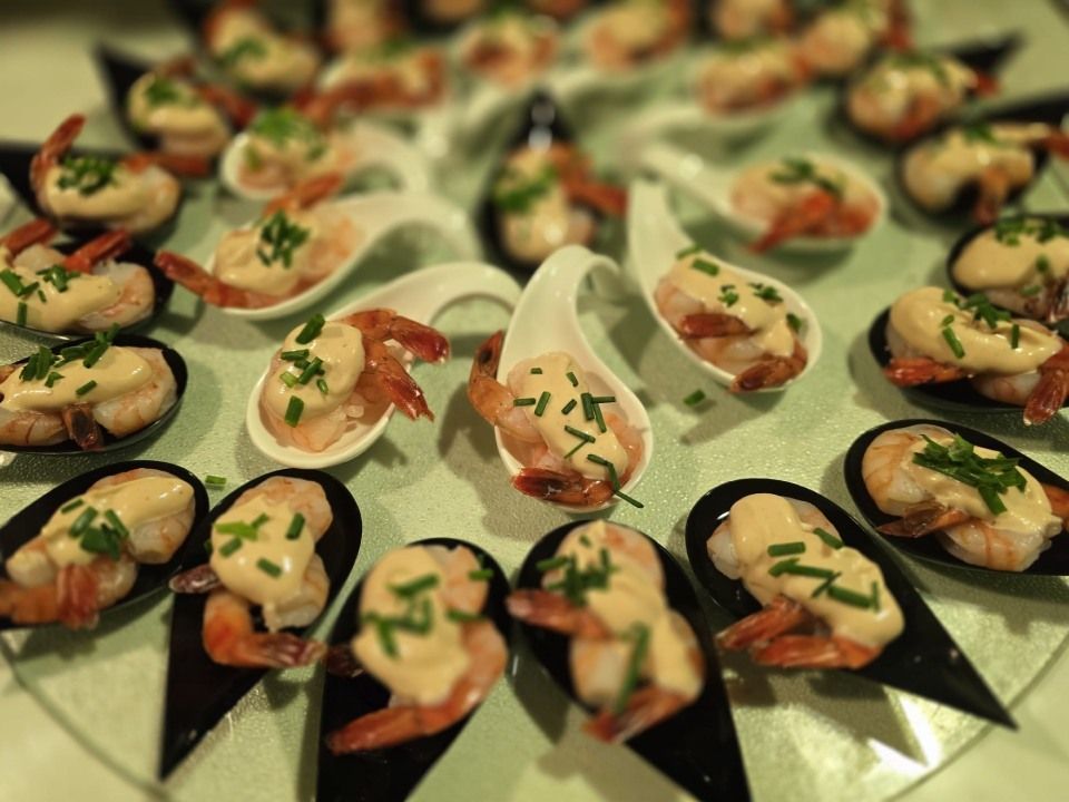 Une assiette de nourriture avec des crevettes sur des cuillères sur une table