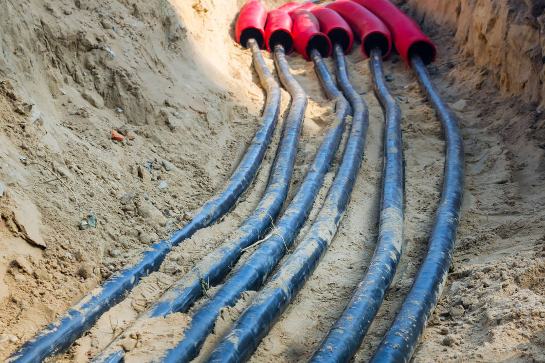 Un tas de fils électriques traînent dans la terre.
