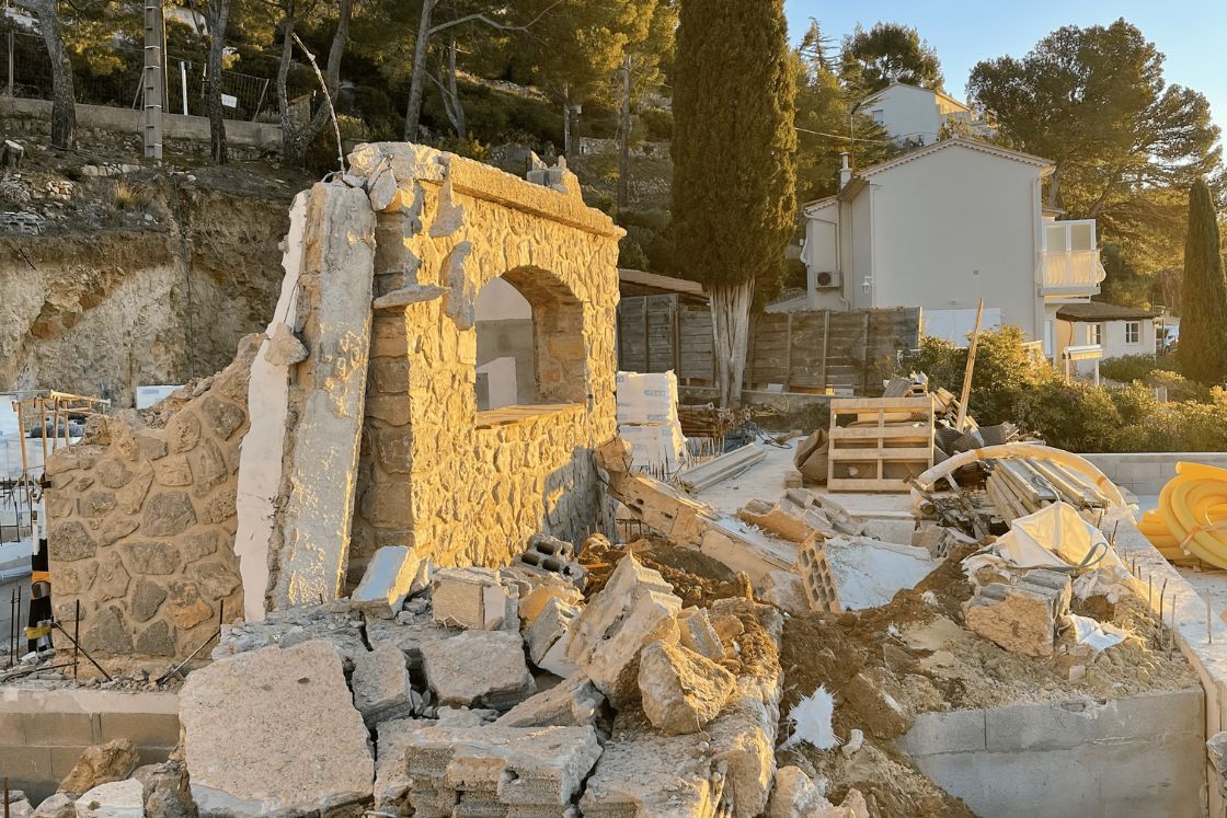 Un bâtiment est en train d'être démoli au milieu d'un chantier.