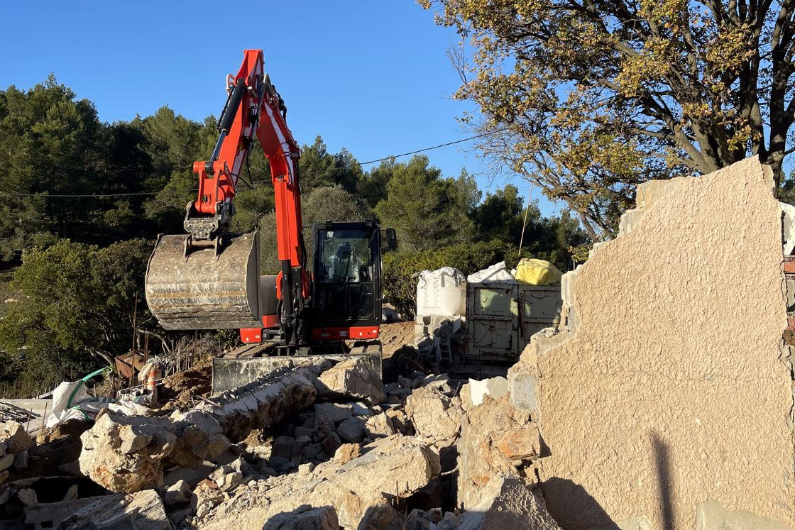 Une grande excavatrice déplace des roches sur un chantier de construction.