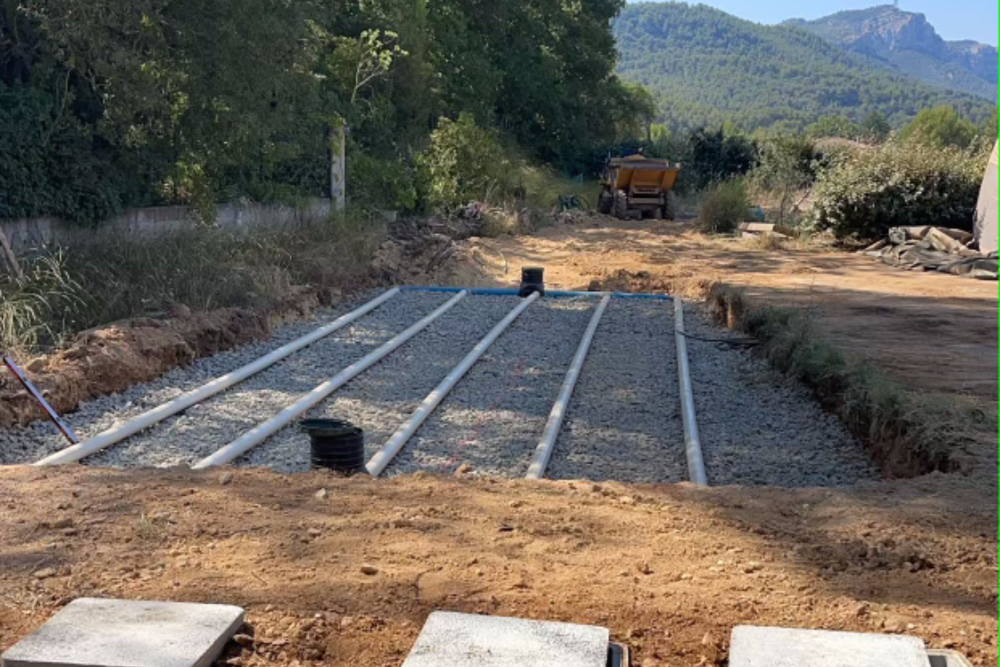 Un camion roule sur un chemin de terre à côté d'un chemin de gravier.