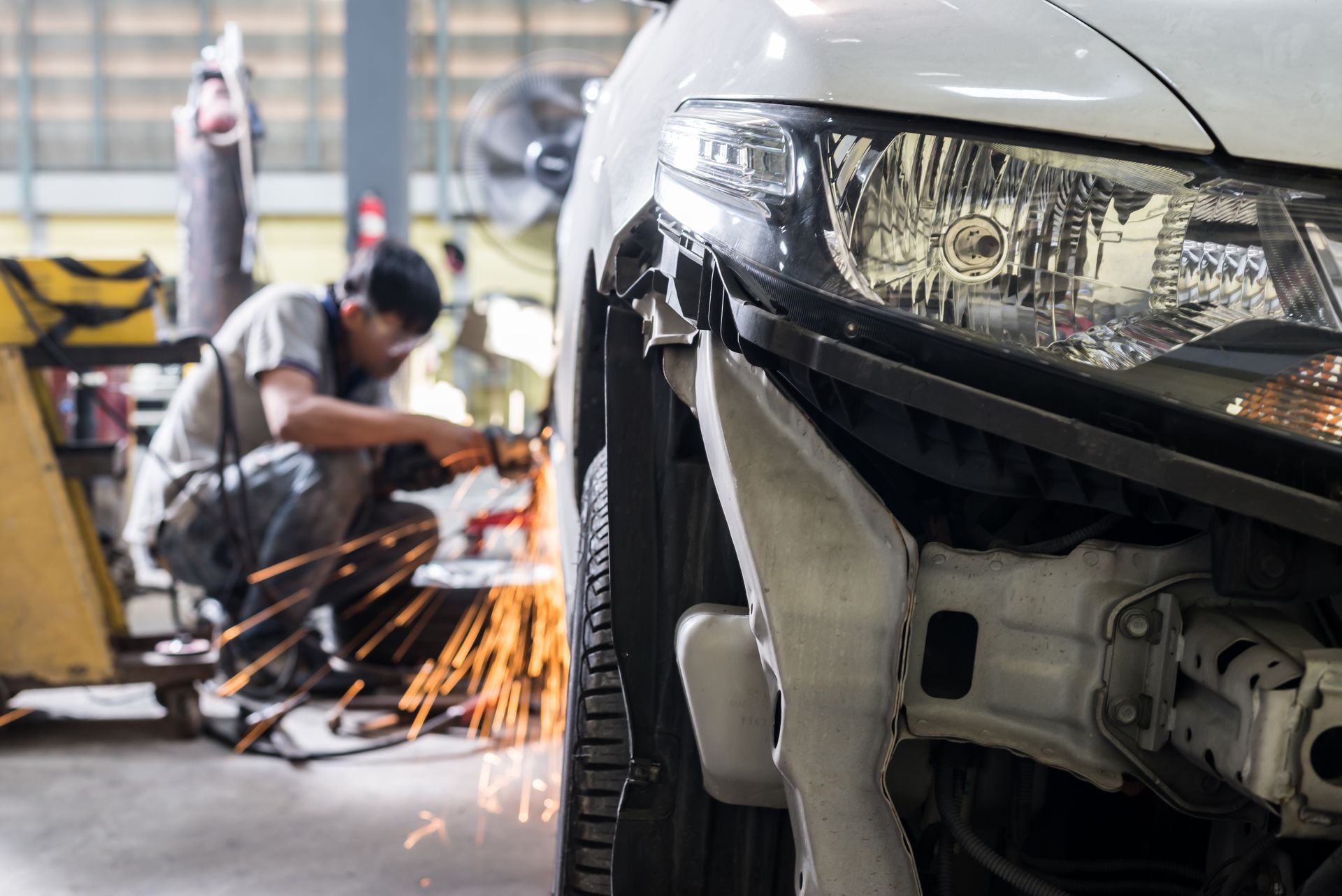 Monte-voiture dans un garage, rampes, bleu et gris métallisé, cadre professionnel.