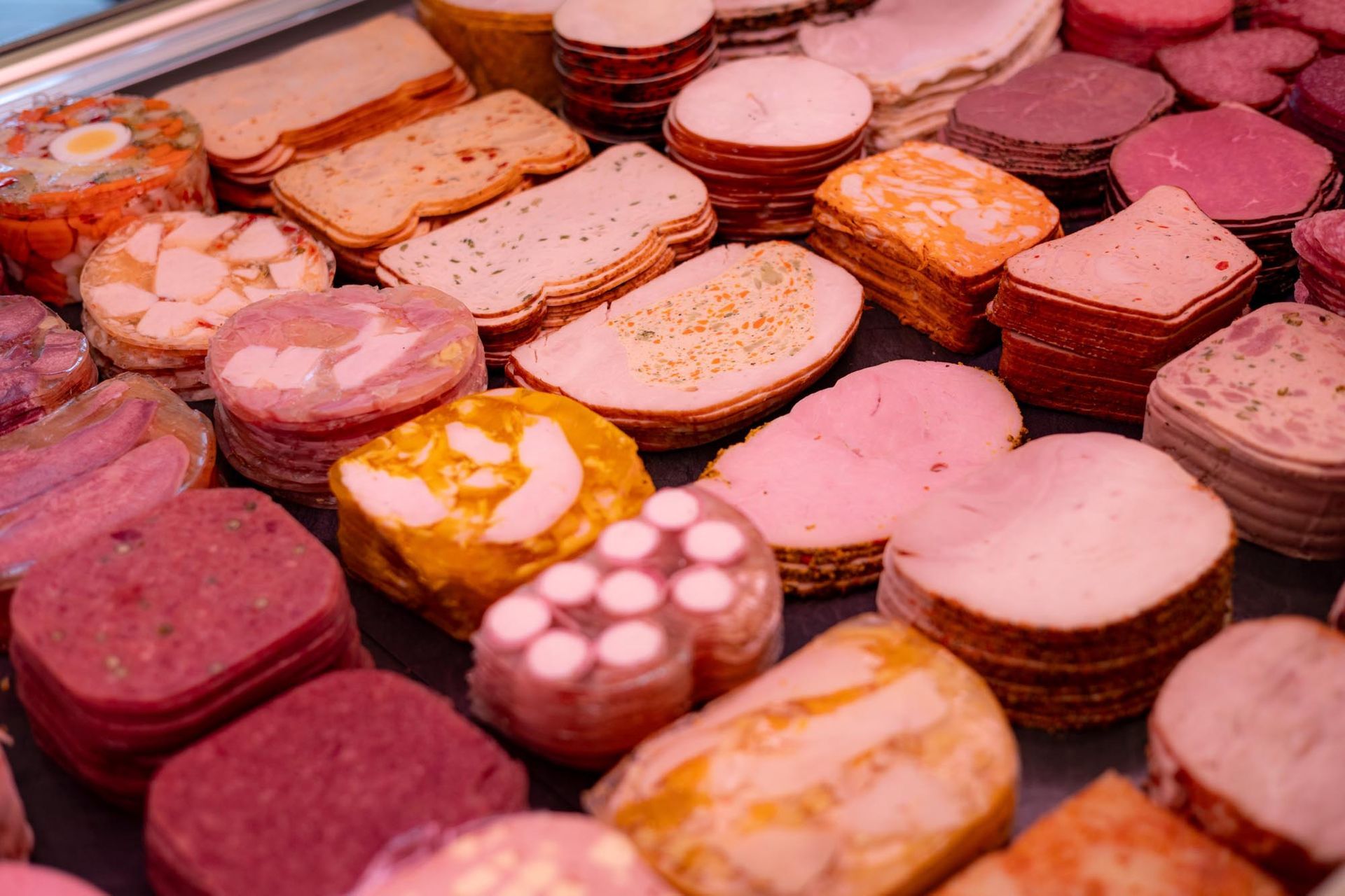 Verschiedene bunte, gestapelte Macarons und Sandwichkekse in einer Gebäckauslage