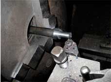 Una persona está cortando un trozo de metal en una máquina.