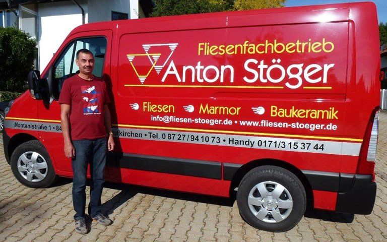 Mitarbeiter vor Unternehmensfahrzeug