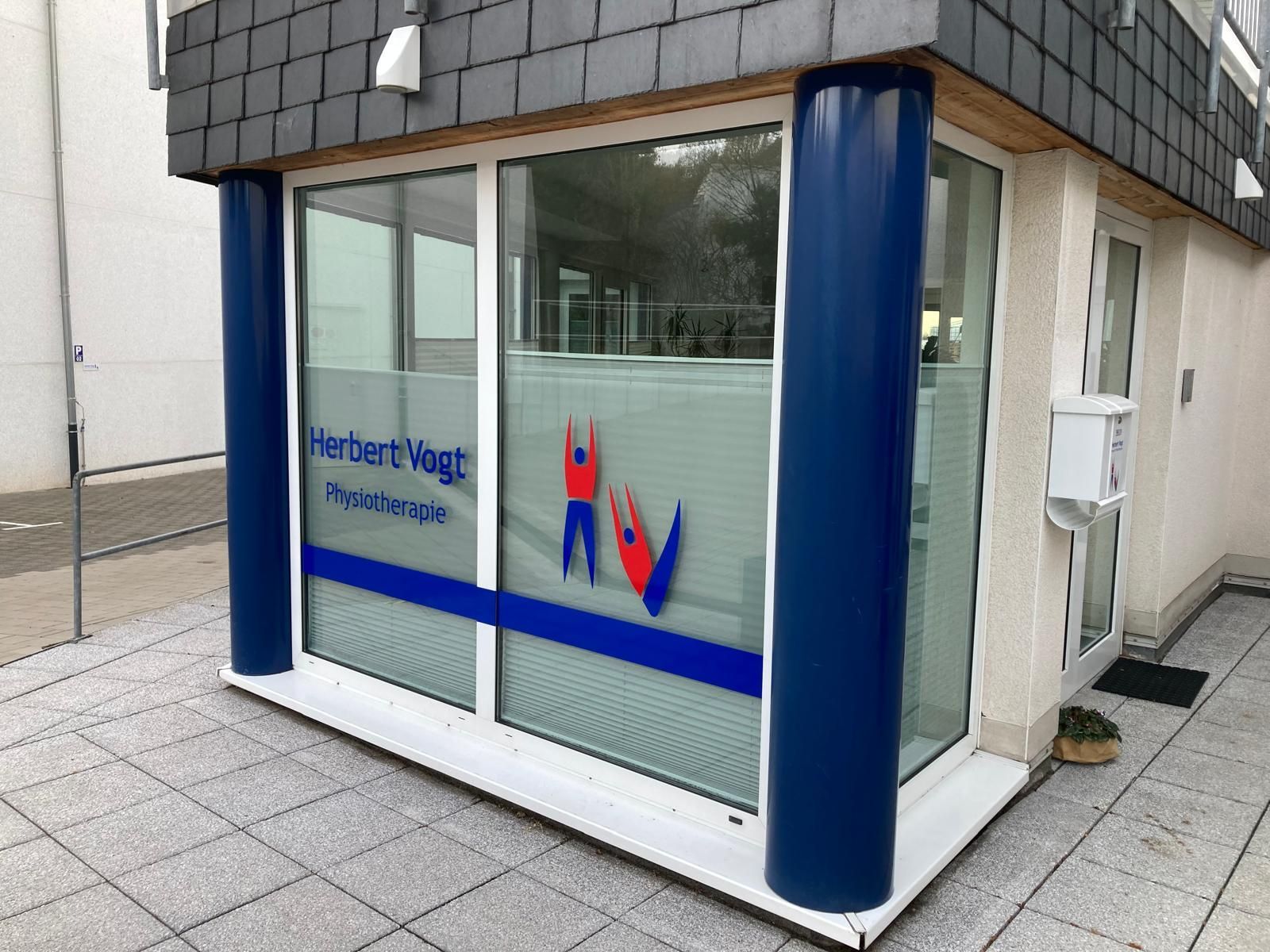 Eine ältere Frau sitzt auf einem Bett und hält die Hand einer Krankenschwester.