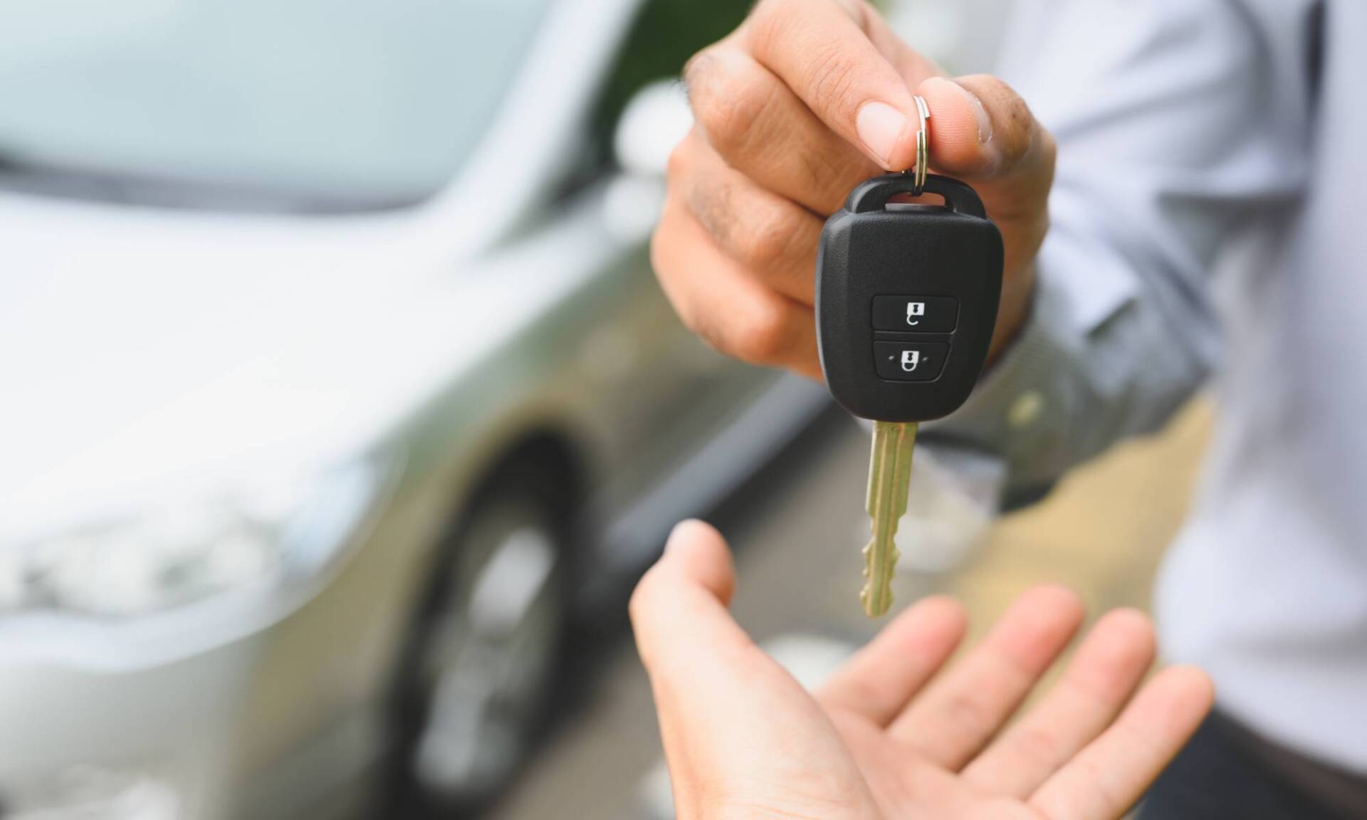Person händigt einen Autoschlüssel aus