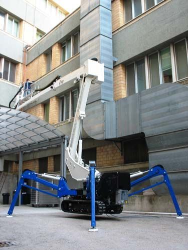 Un elevador araña está estacionado frente a un edificio.