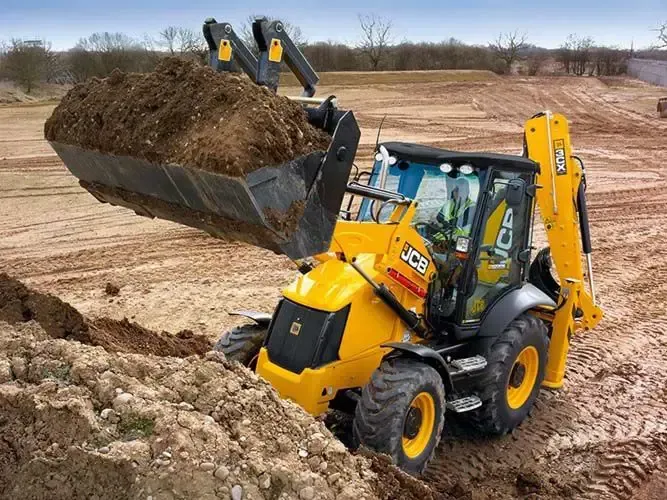 Una retroexcavadora amarilla y negra está cargando tierra en un balde en un sitio de construcción.