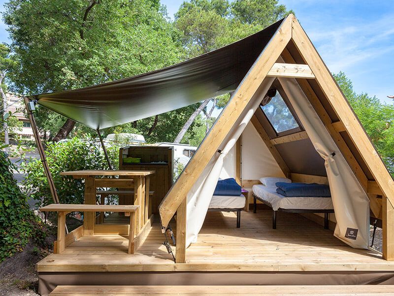 Une tente de camping en bois avec petite terrasse