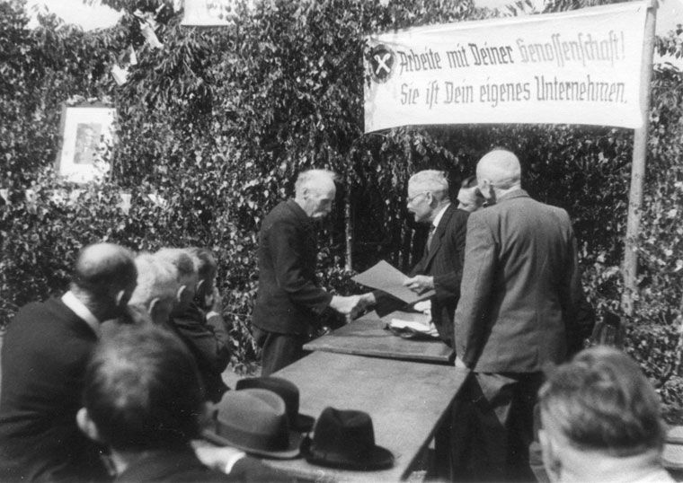 Schwarz-Weiß-Bild, Unternehmer einer Genossenschaft reichen sich die Hand