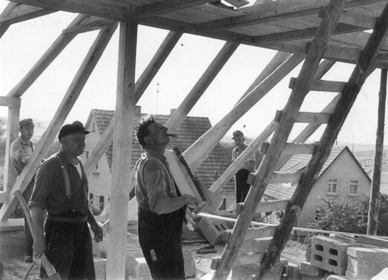 Schwarz-Weiß-Bild, Männer bauen ein Dach