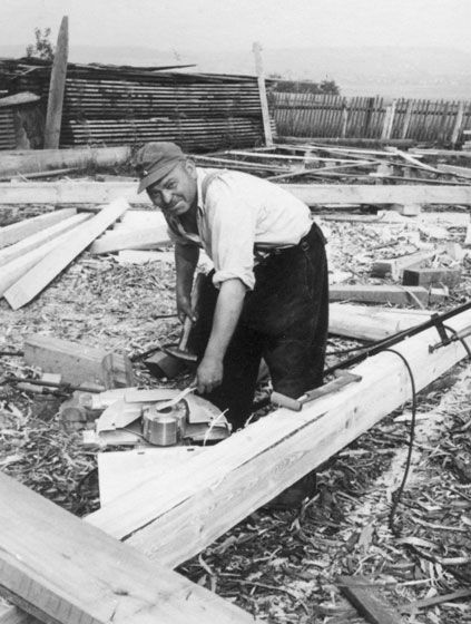 Schwarz-Weiß-Bild, ein Mann befestigt Holzbalken