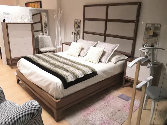 Un moderno espacio de exposición de dormitorios que incluye una cama con