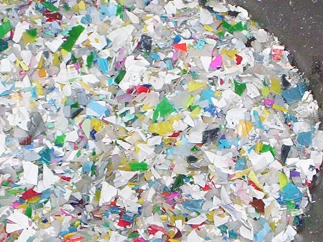 Un montón de restos de plástico triturados, de colores, de diferentes formas y tamaños, probablemente destinados al reciclaje.