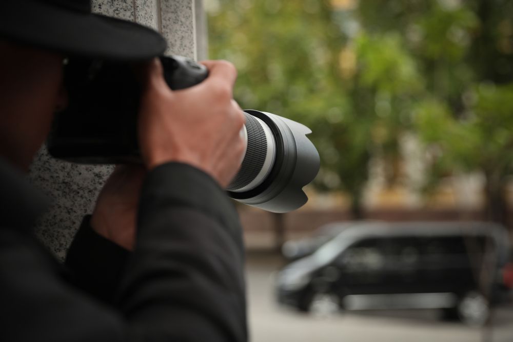Un hombre con sombrero está tomando una fotografía con una cámara.
