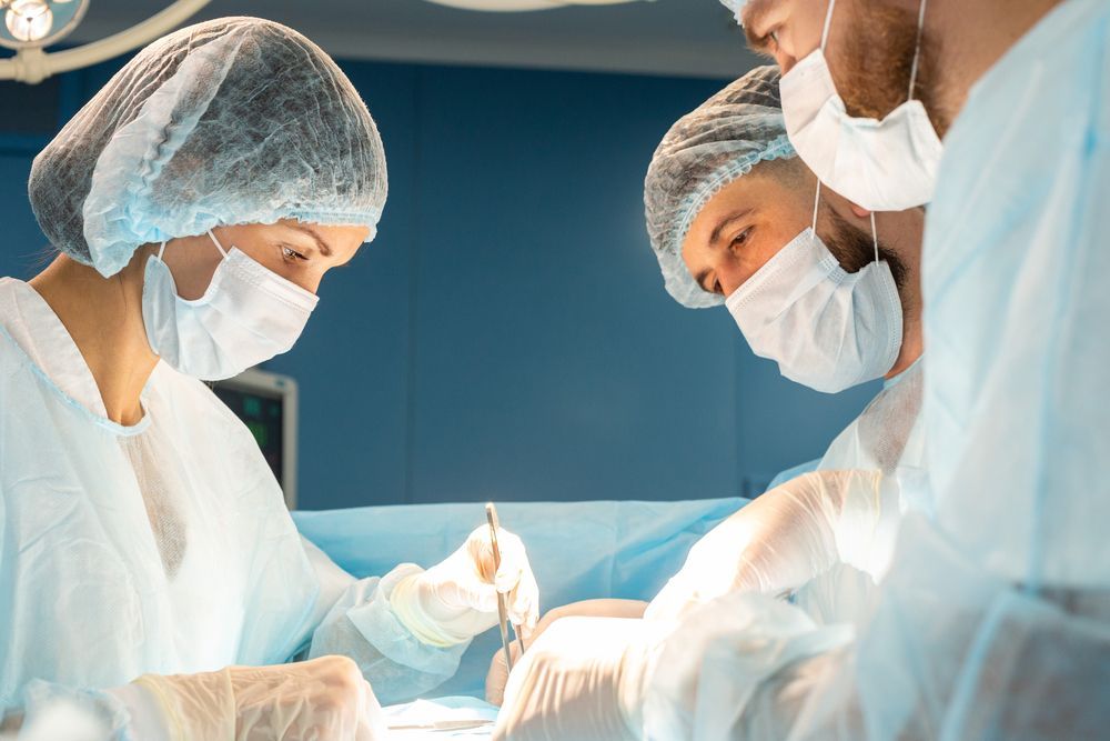 Un grupo de cirujanos está operando a un paciente en un quirófano.