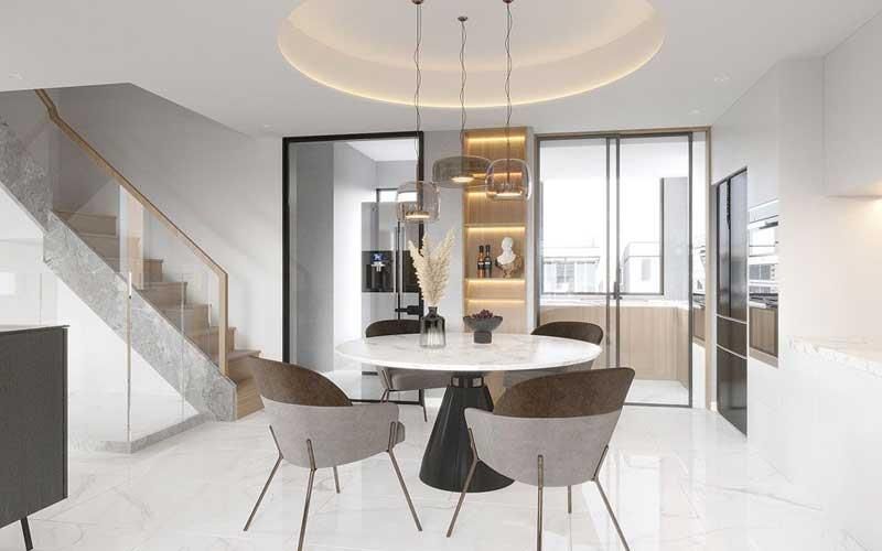 Ein Esszimmer mit einem runden Tisch und Stühlen und einer Treppe.