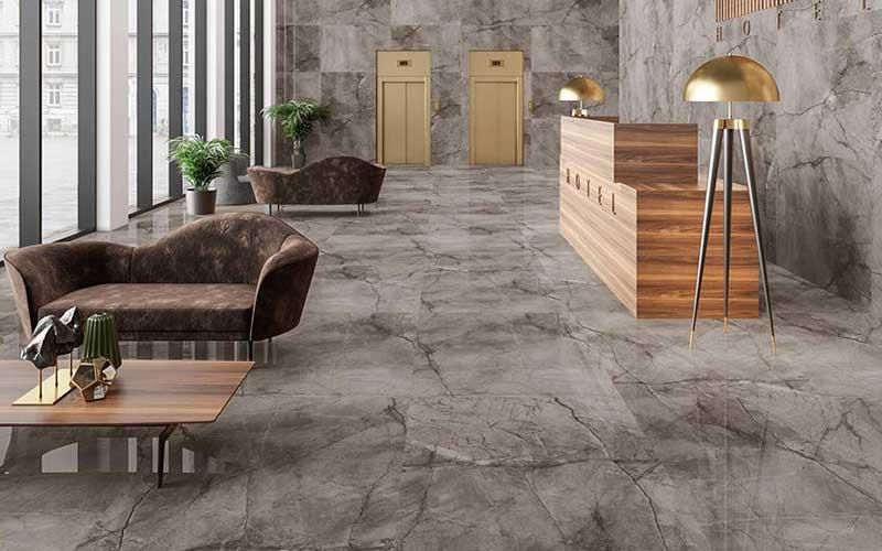 Eine Lobby mit Couch, Tisch, Lampe und Aufzügen.