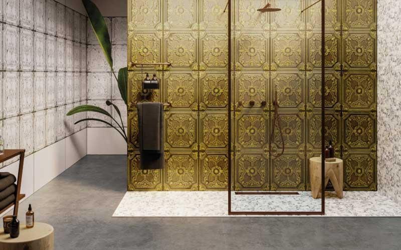 Ein Badezimmer mit goldenen Fliesen und einer ebenerdigen Dusche.