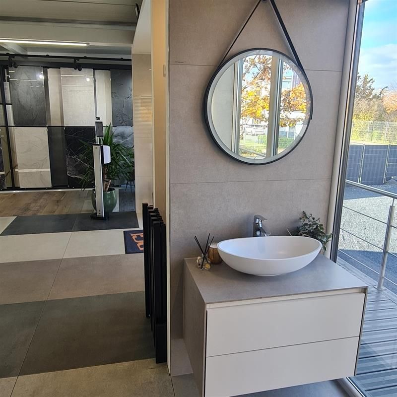 Ein Badezimmer mit Waschbecken und Spiegel an der Wand.