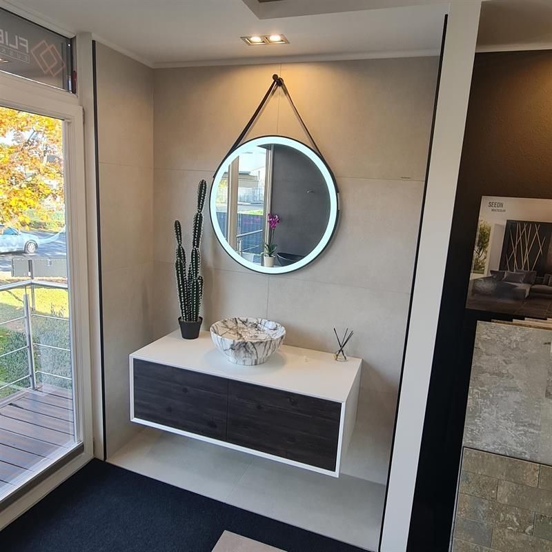 Ein Badezimmer mit Waschbecken und Spiegel an der Wand