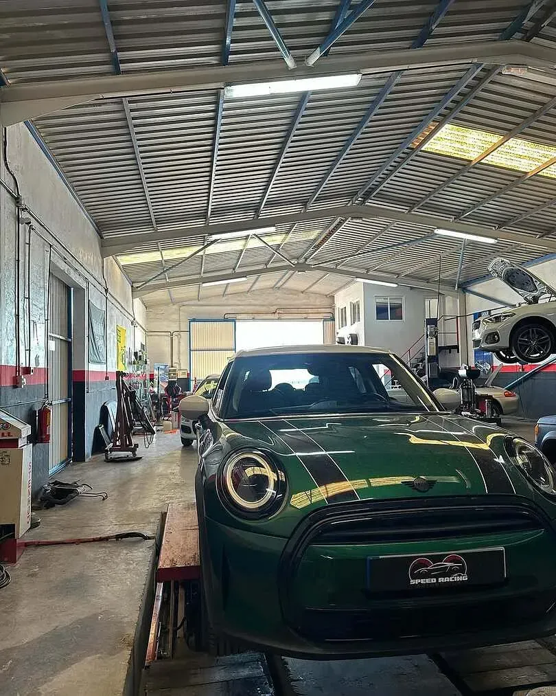 Un Mini Cooper verde está aparcado en un garaje.