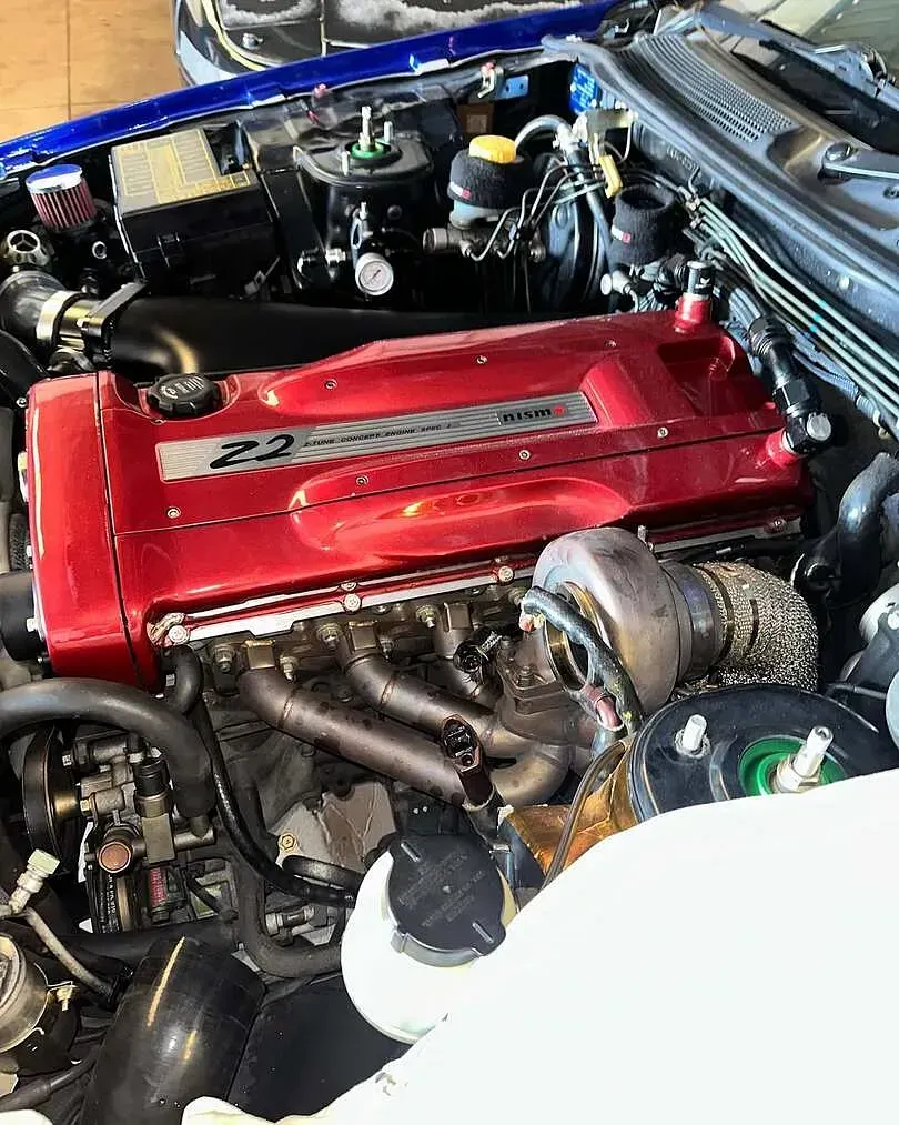 Un primer plano de un motor de automóvil con el capó abierto.