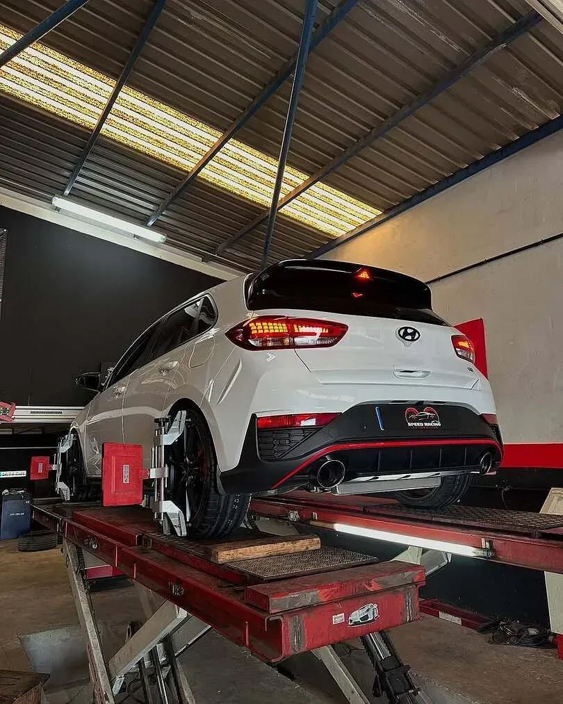 Un coche blanco está estacionado en un elevador en un garaje.