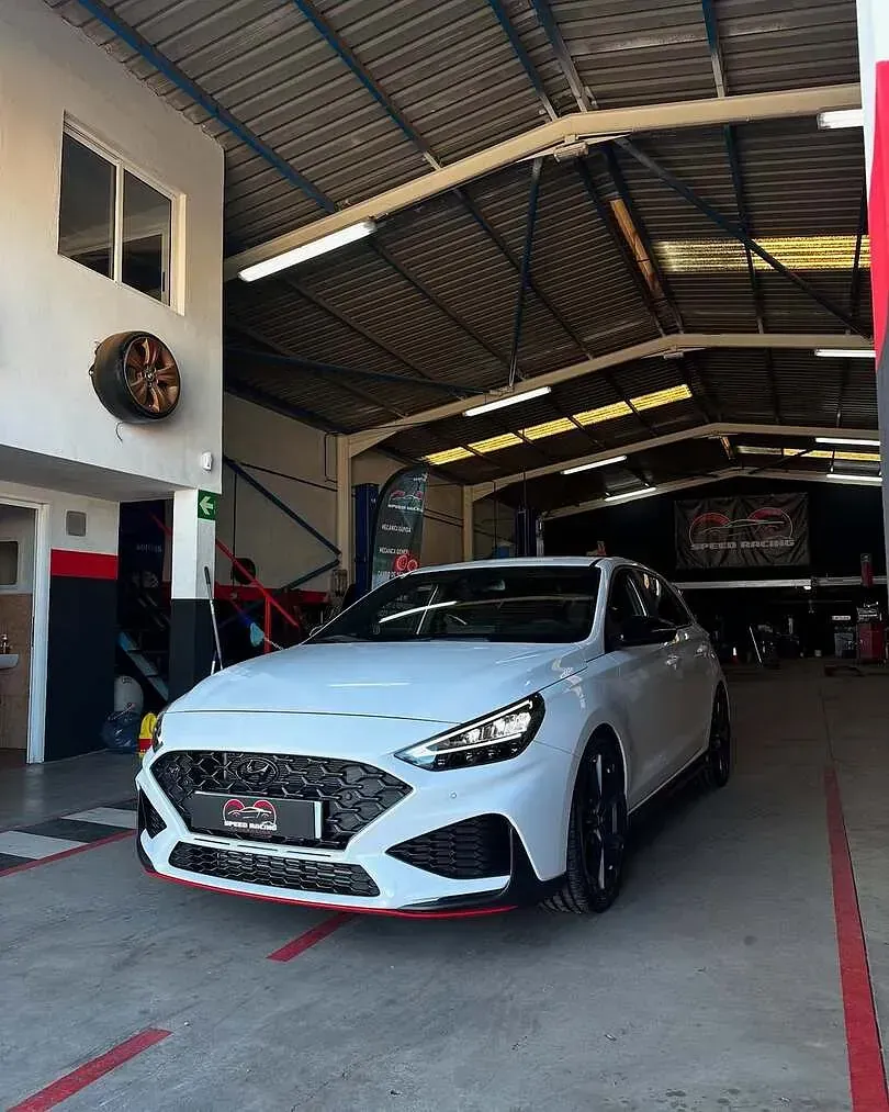 Un coche blanco está aparcado en un garaje.