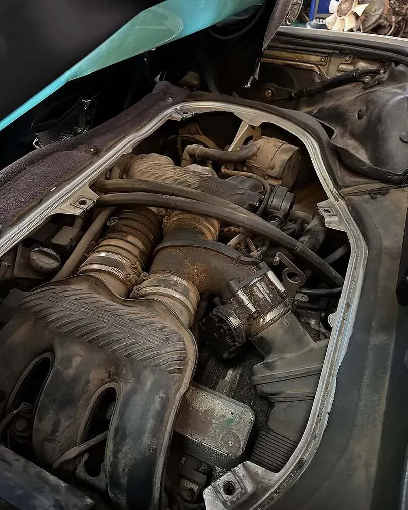 Un primer plano de un motor de automóvil con el capó abierto.