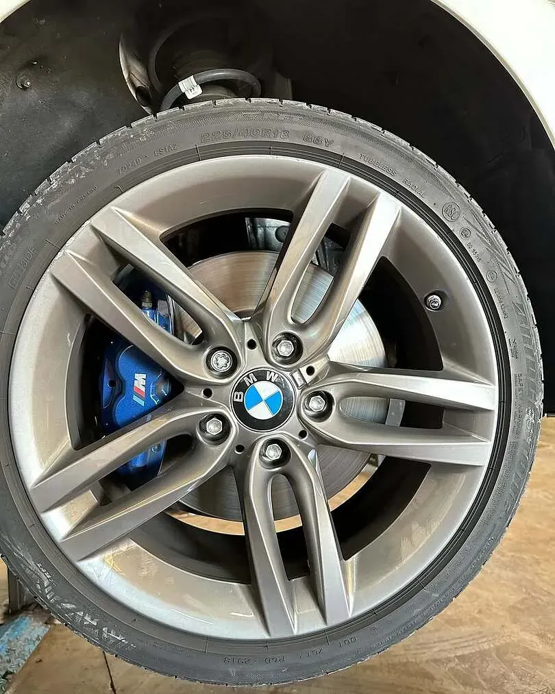 Un primer plano de una rueda BMW con pinzas de freno azules.