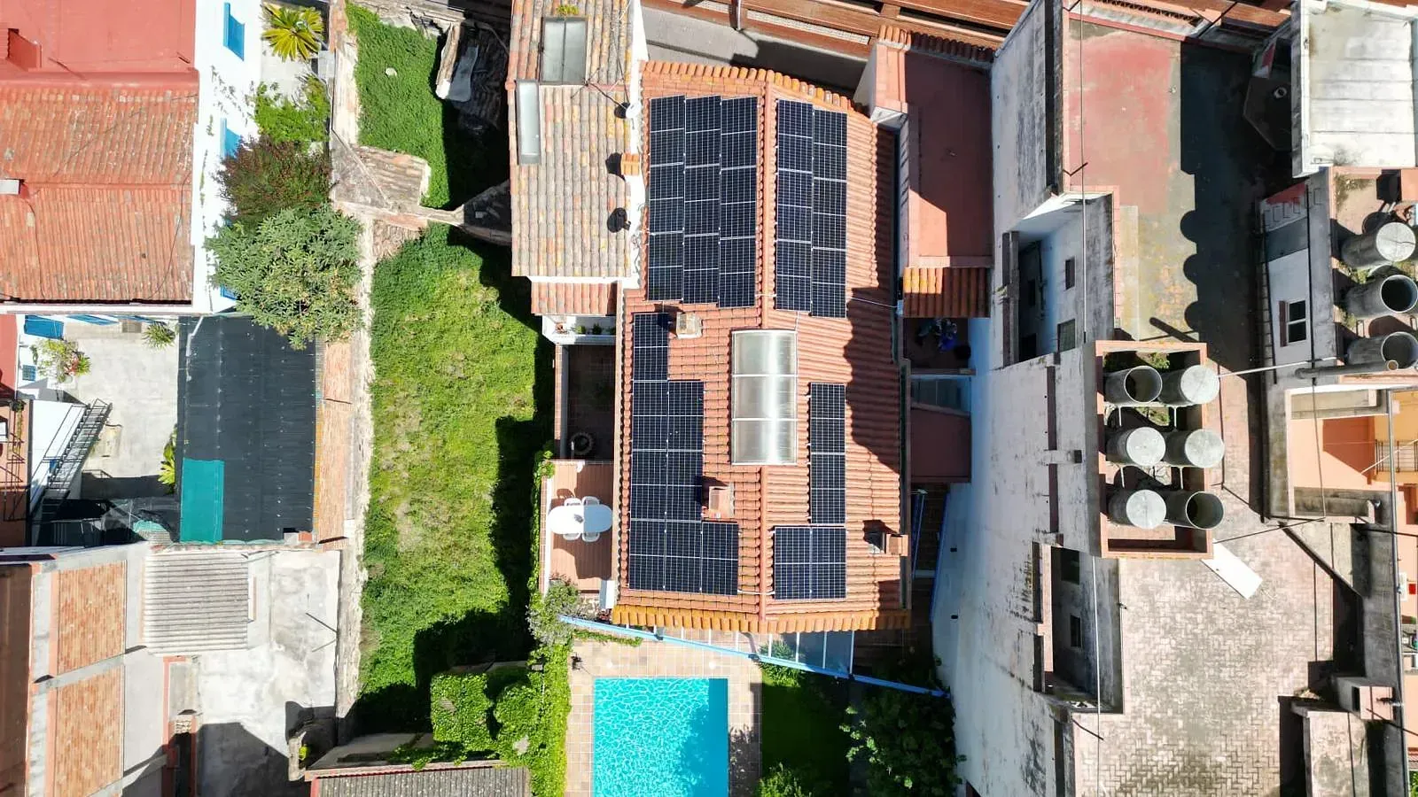 Una vista aérea de una casa con paneles solares en el techo.