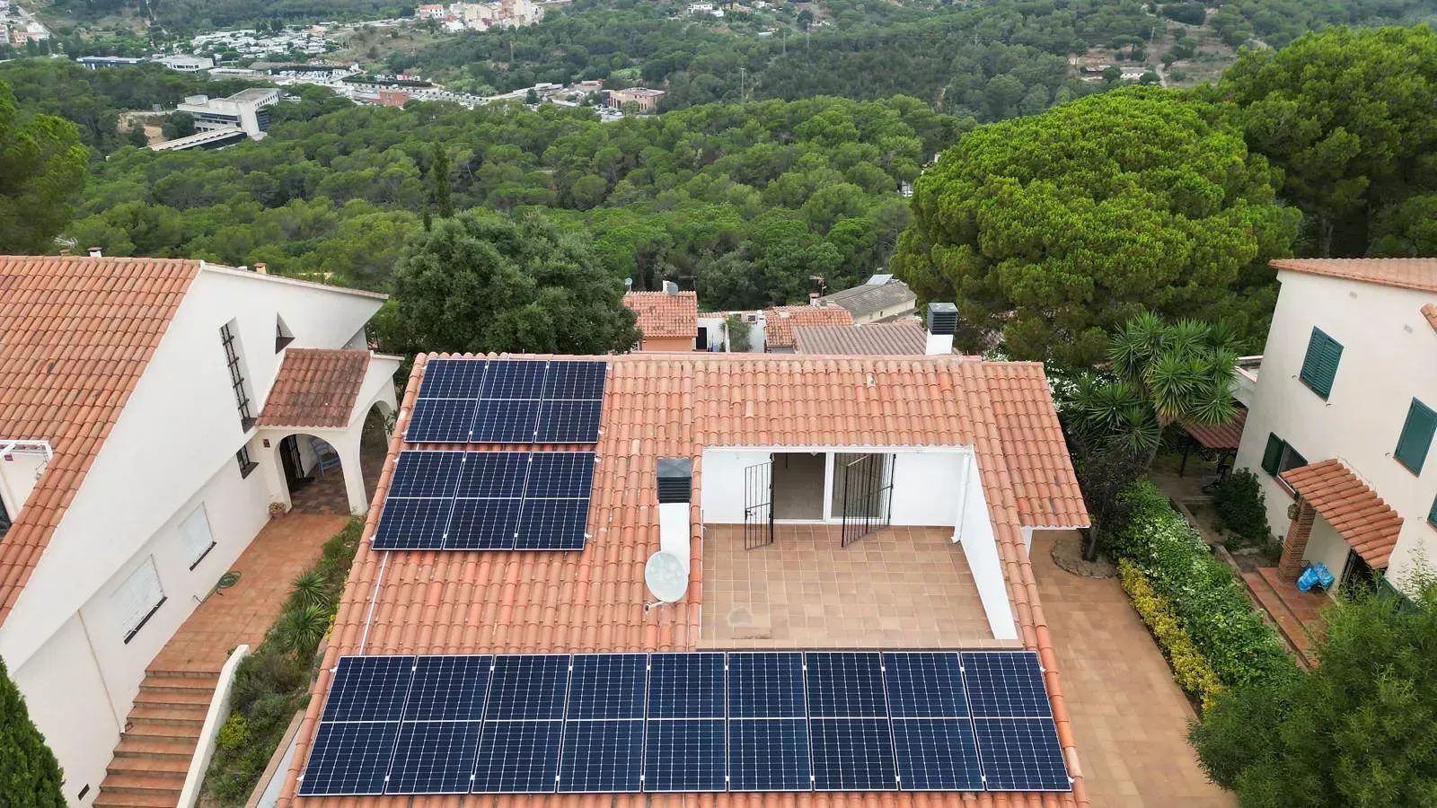 Una vista aérea de una casa con paneles solares en el techo.
