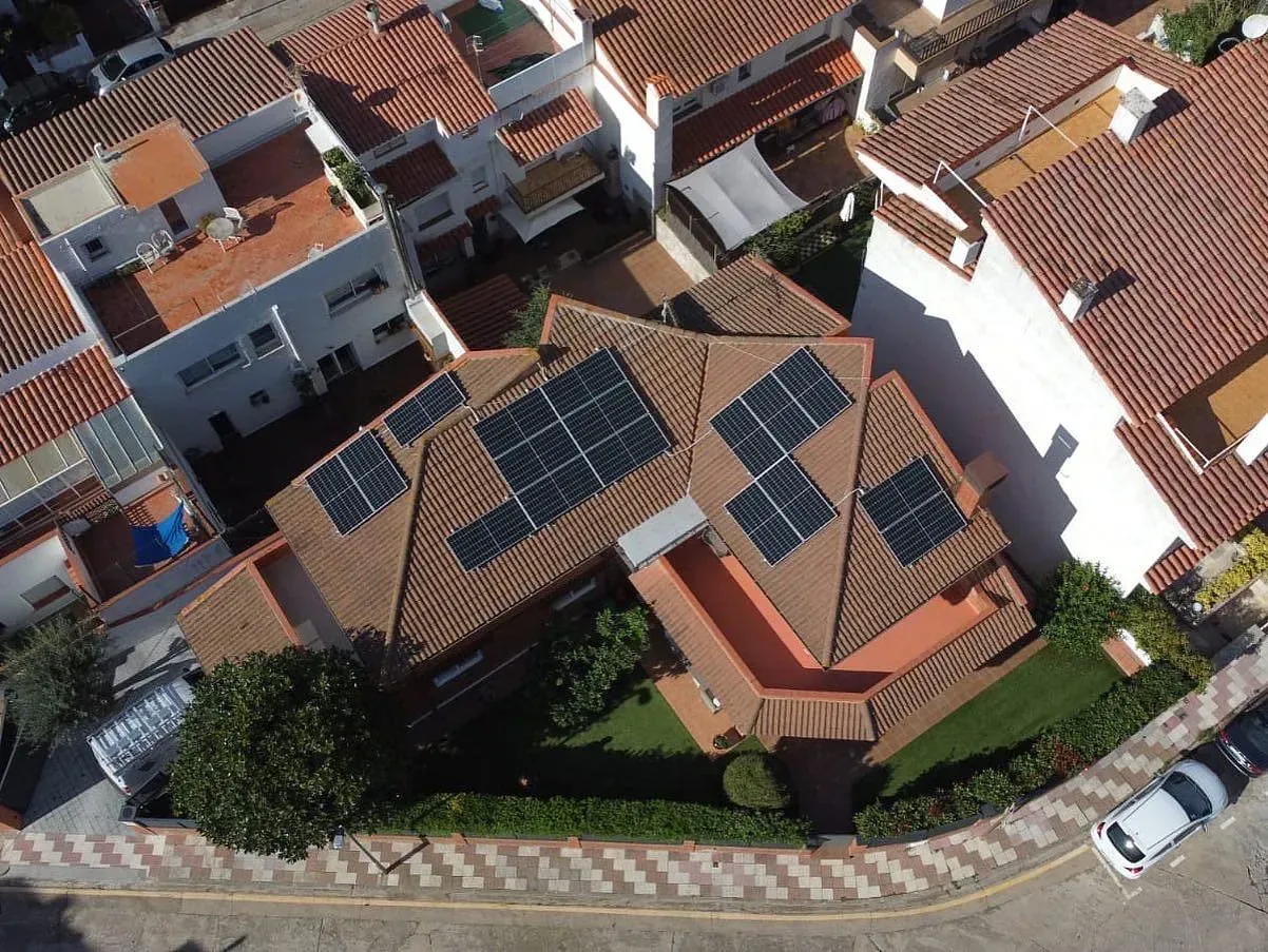 Una vista aérea de una casa con paneles solares en el techo.