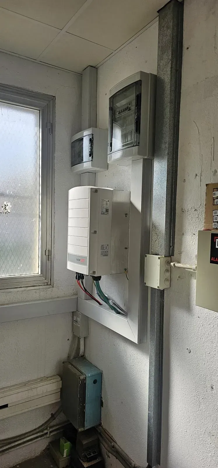 Una habitación con muchos equipos eléctricos en la pared y una ventana.