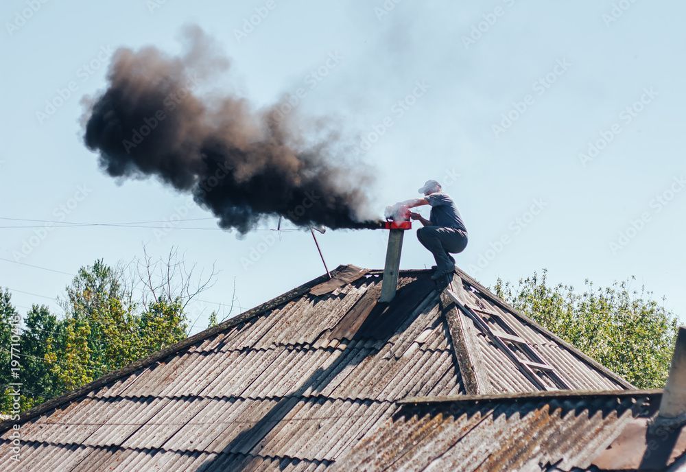 Kaminfeger bei der Arbeit auf einem Dach