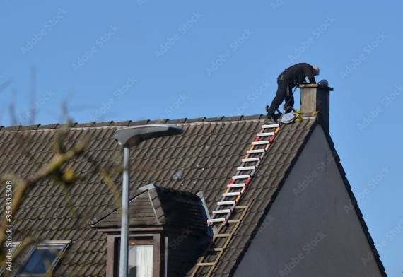 Kaminfeger bei der Arbeit auf einem Dach