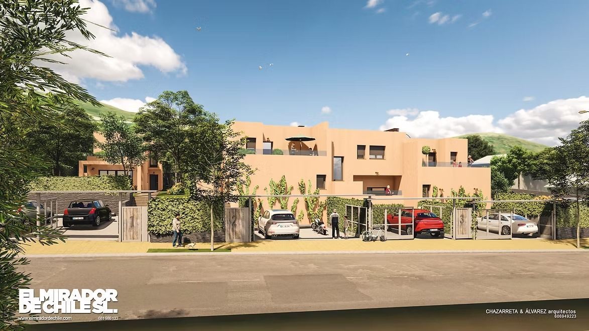 Edificio de apartamentos de color beige con balcones, árboles, coches aparcados y una calle enfrente bajo un cielo azul.