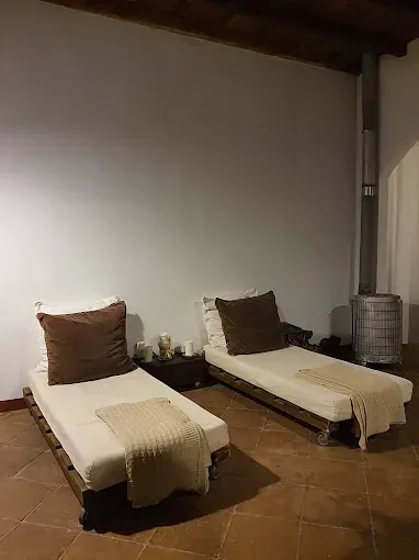 Dos sillones con almohadas y mantas marrones en una zona de spa poco iluminada.