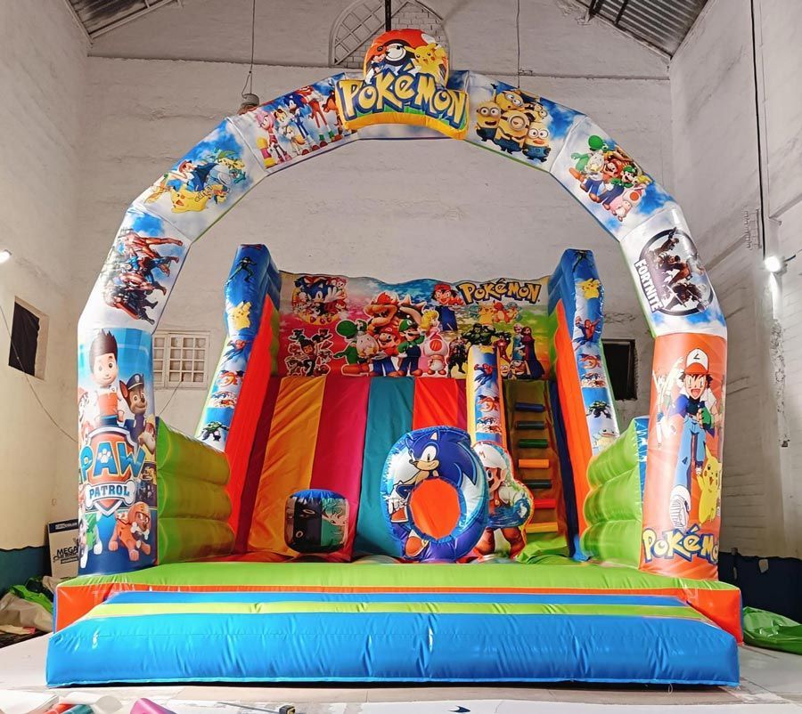 Casa inflable con temática de Pokémon, con tobogán, arco y personajes coloridos dentro de un edificio.