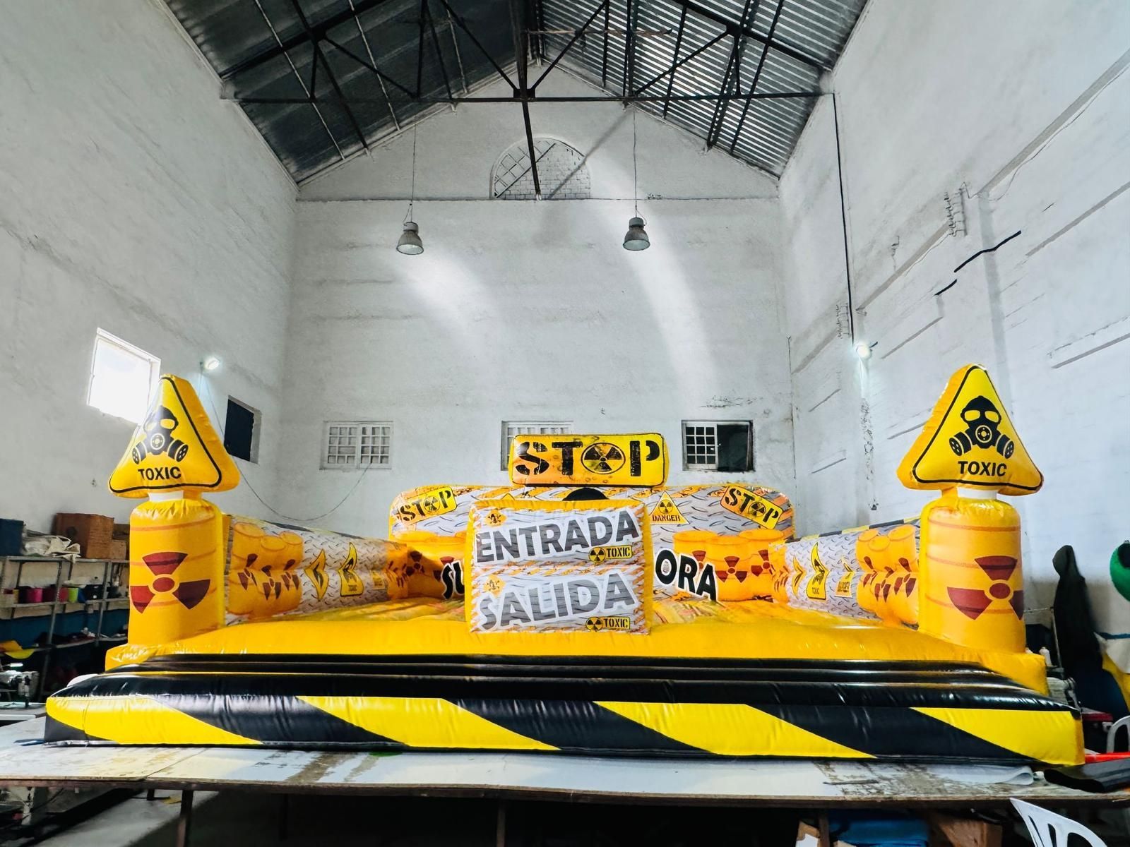 Un gran cartel de advertencia inflable de color amarillo y negro en un almacén.