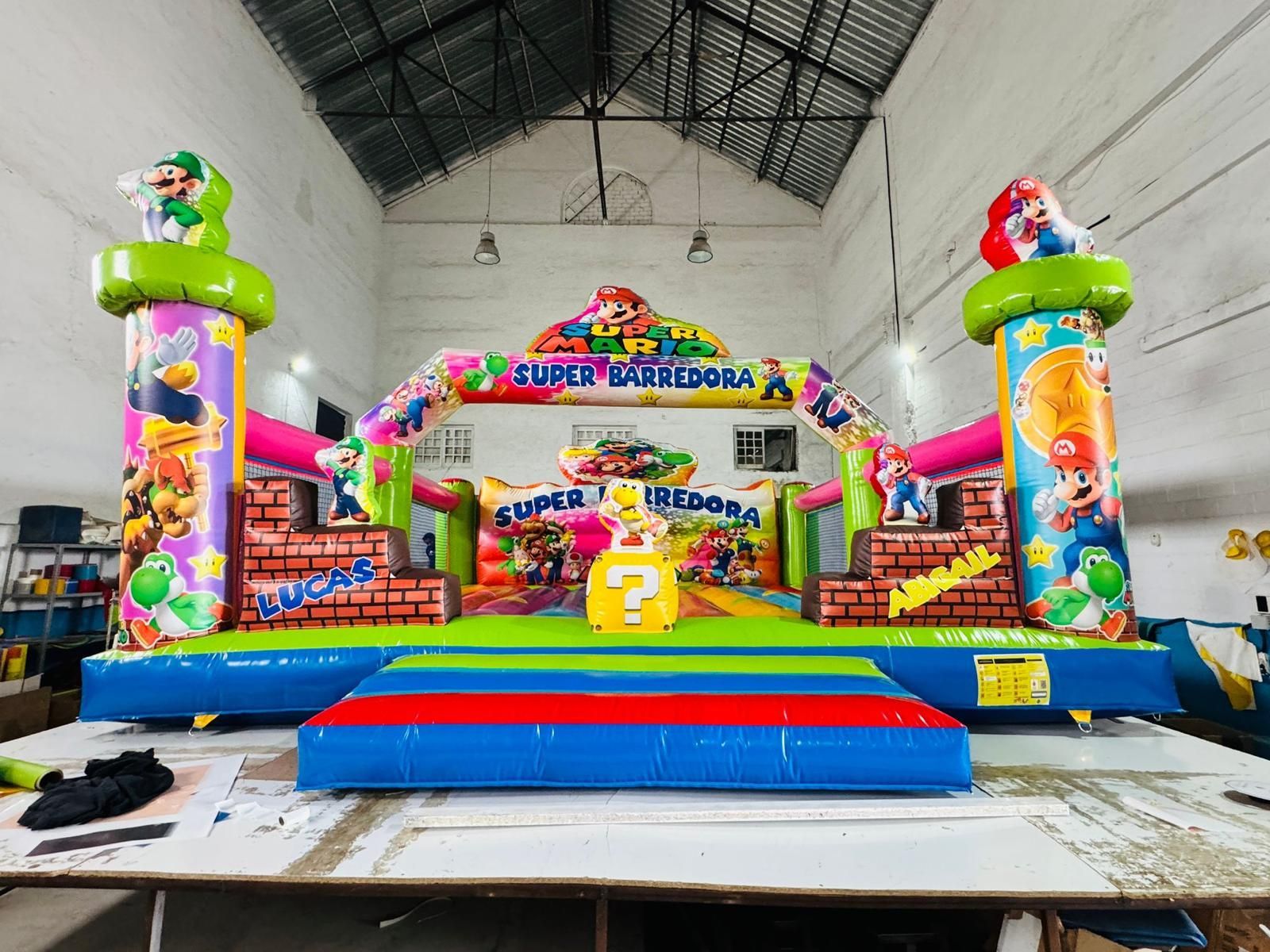 Un gran castillo inflable con Mario y Yoshi en él.