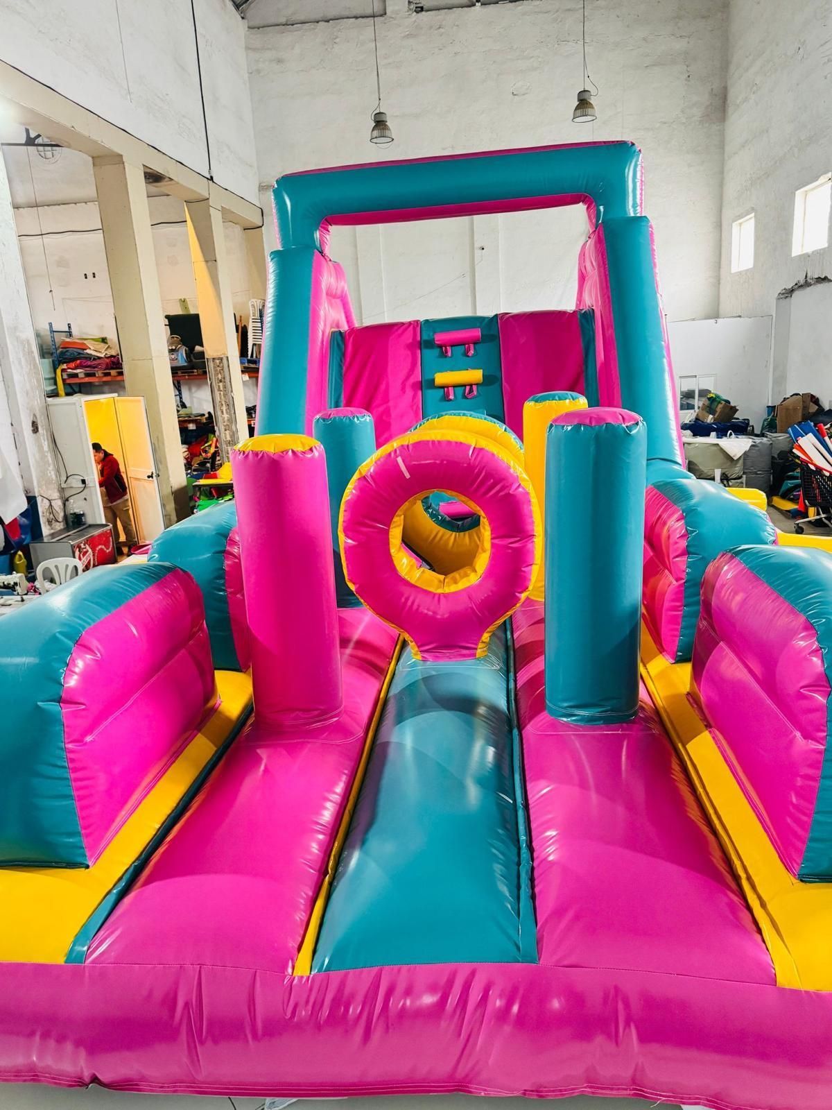 Una casa inflable rosa y azul está en un almacén.