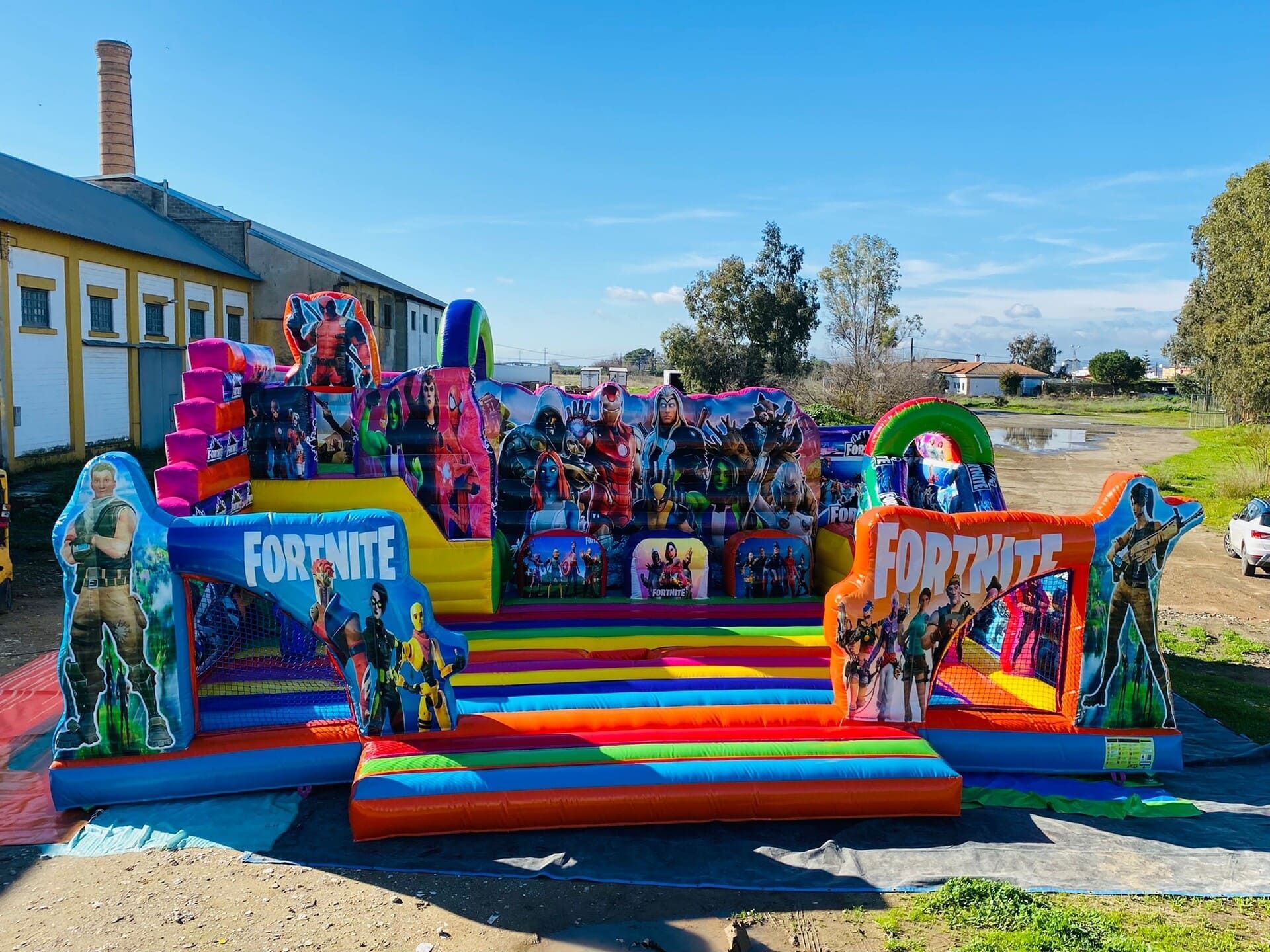Una gran casa inflable de Fortnite se encuentra sobre un campo de tierra.