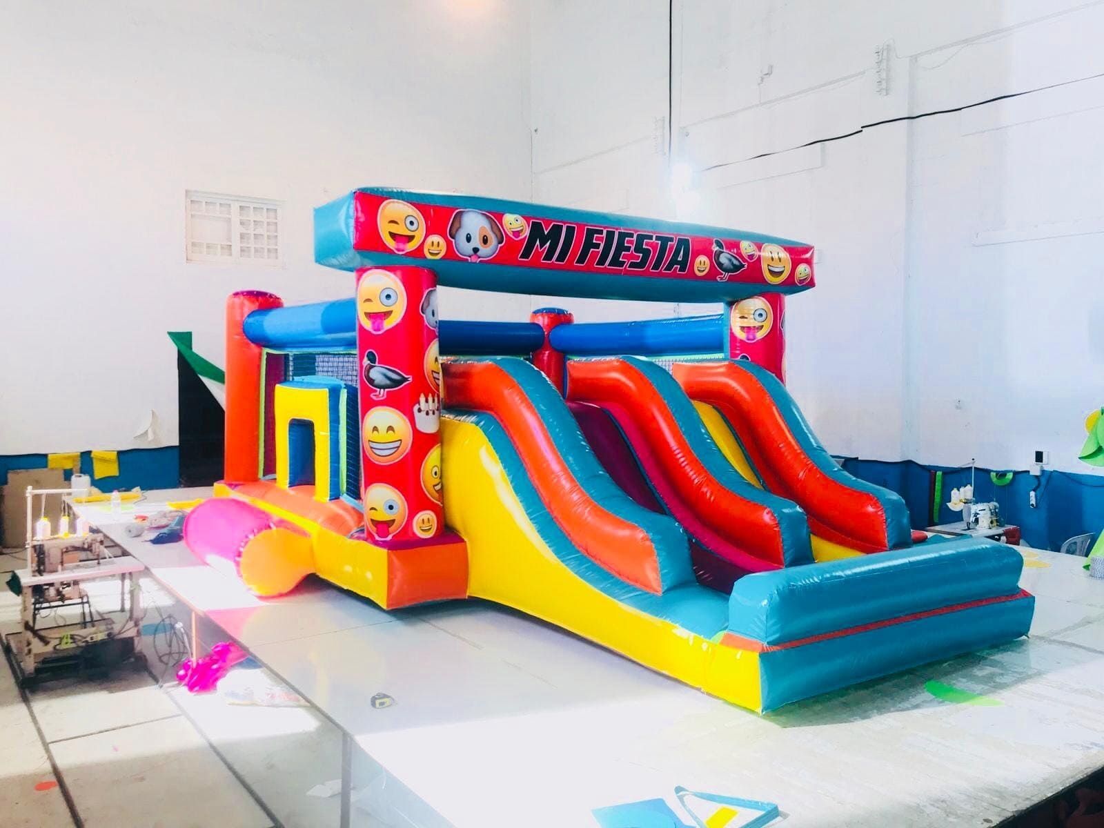 Una casa inflable colorida con caras sonrientes está sobre una mesa.