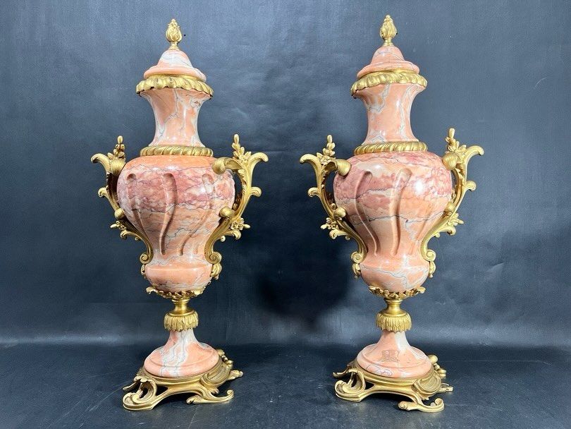 Dois vasos ornamentados na cor coral com detalhes em dourado.