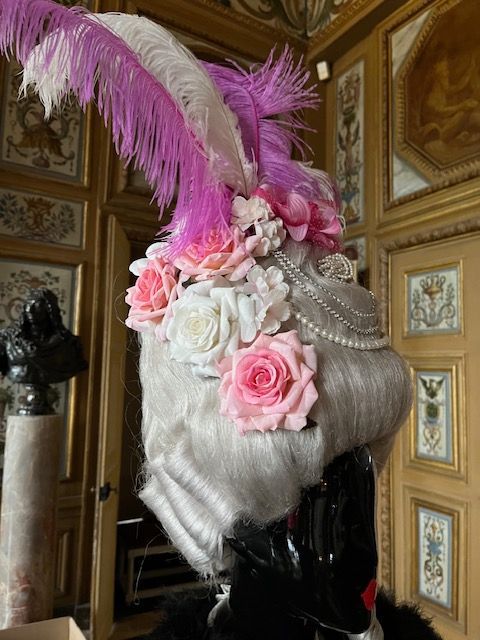 Perruque avec de grandes plumes violettes et blanches